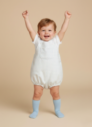  A white and blue checkered baby jumpsuit for infants aged 0-18 months. The jumpsuit features a loose, comfortable fit and a classic checkered pattern.