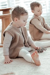 Cozy, teddy-style baby vest in a warm cacao brown color. Made of soft, boucle fabric for a plush, textured look. Available in sizes from newborn to 4 years.