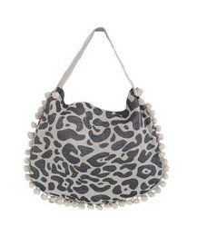 A large, tote-style beach bag in a vibrant blue and turquoise color scheme, with a beige accent. The bag features a pom-pom trim in a contrasting navy blue color, adding a playful and stylish touch.