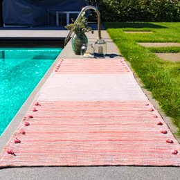 Grey and red yoga rug with a textured surface for grip and comfort during yoga practice.