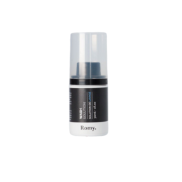 Creamy white washing solution in a clear glass bottle with a black cap.