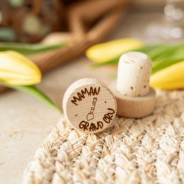 "A cork and wood wine bottle stopper with the text 'Maman Grand Cru' engraved on it, surrounded by other wooden stoppers with various engraved designs."

The product is a wine bottle stopper made of cork and wood, with the text "Maman Grand Cru" engraved on it. The stopper is surrounded by other wooden stoppers with various engraved designs, suggesting a collection or set of similar products. The image showcases the materials (cork and wood), the style (traditional wine stopper), and the text and shapes (engraved designs) that are relevant for this product.