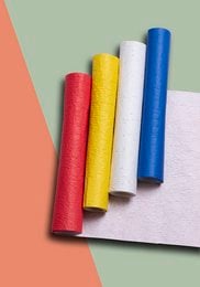Colorful wrapping paper rolls in red, yellow, blue, and white. The wrapping paper has a jungle or nature-inspired pattern.