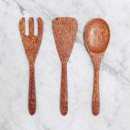 Wooden cooking utensils including a fork, spatula, and spoon. The utensils have a rustic, natural appearance with a warm, reddish-brown color.