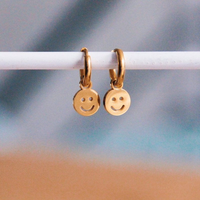 Bøjleøreringe i rustfrit stål med smiley – guld