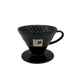 A black ceramic V60 coffee dripper with a ribbed design and a handle. This pour-over coffee maker is part of the "Colour Edition" line and is suitable for brewing specialty coffee at home.