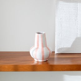 Handpainted ceramic vase with a rounded, bulbous shape and a white and pink color scheme.