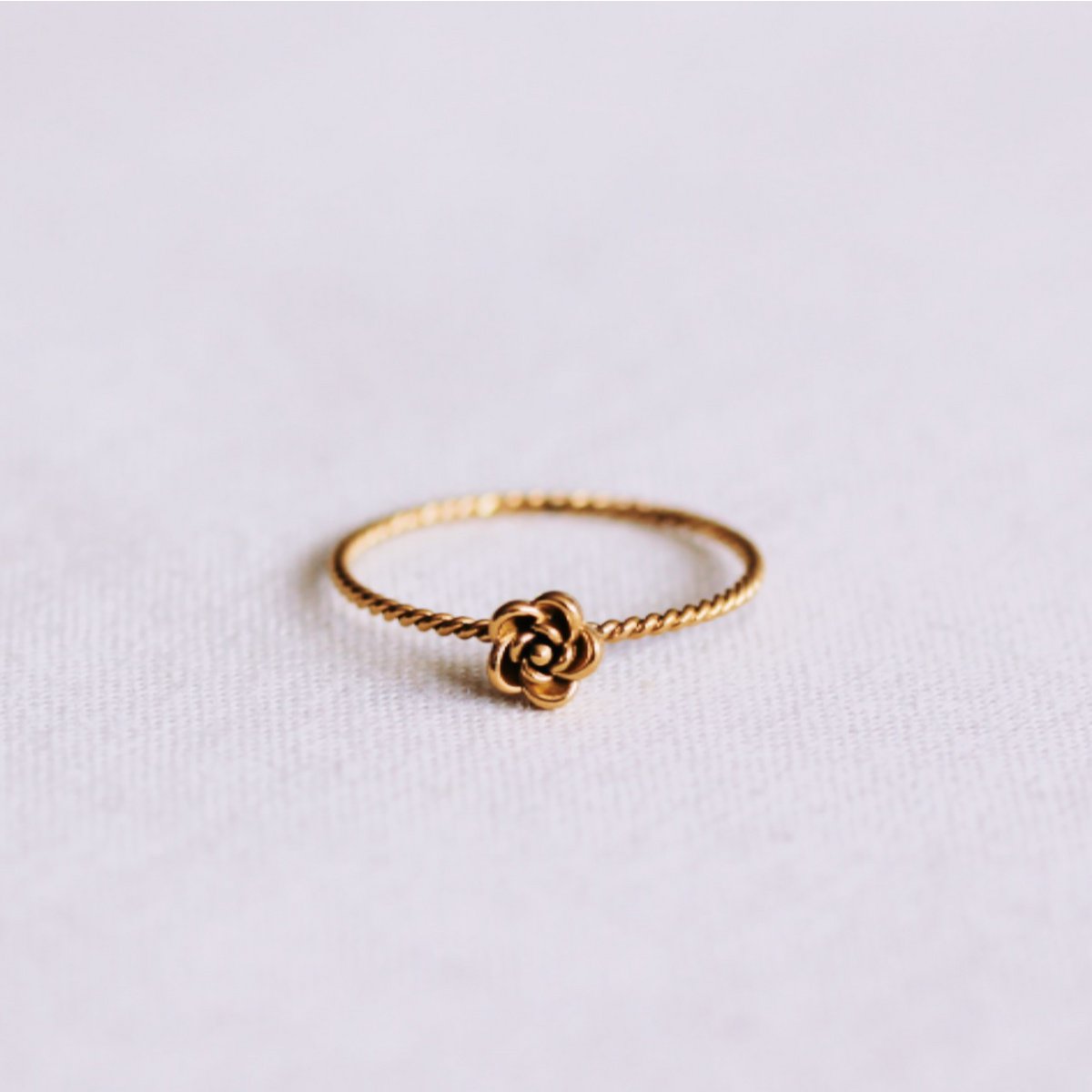 Minimalistischer gedrehter Ring mit einer kleinen Rose