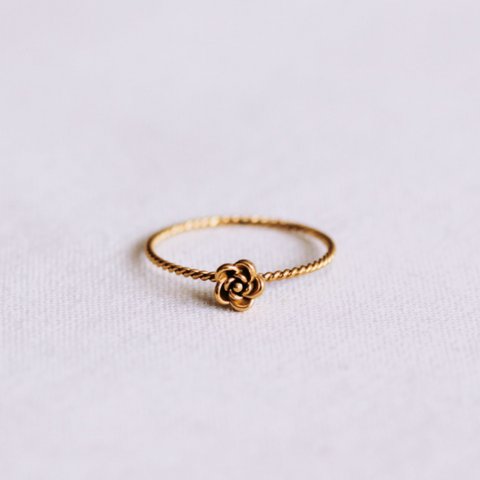 Minimalistischer gedrehter Ring mit einer kleinen Rose