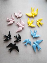 Conjunto de 3 andorinhas Primavera, decorative statues available in various colors including pink, black, light blue, navy blue, white, burgundy, and yellow. The statues feature stylized swallow shapes in a variety of pastel shades.
