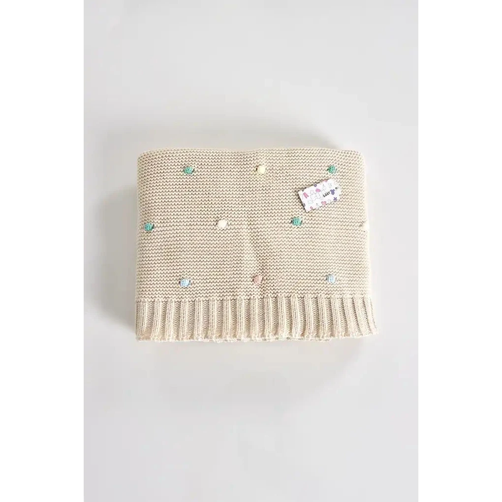 Baby striktæppe med farverige pomponer