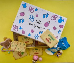 Box of personalized biscuits with the theme "Entre Filles!" Colorful box with floral and heart-shaped designs. Biscuits decorated with question marks in various colors.