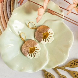 Rose gold, gold, and white leather drop earrings with floral design.