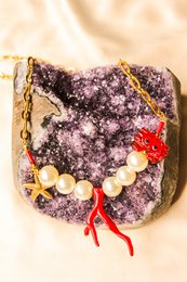 Colorful charm necklace with starfish, pearls, and red accents.