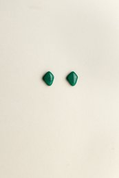 Emerald green statement earrings with a bold, geometric shape.