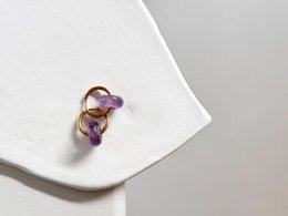 Amethyst hoop earrings with a delicate, elegant design featuring a purple gemstone.