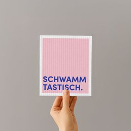  Sponge cloth with the text "Schwamm tastisch" (Sponge delicious in German). The sponge cloth is pink and white in color.
