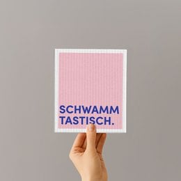 Sponge cloth with the text "Schwamm tastisch" (Sponge delicious in German). The sponge cloth is pink and white in color.