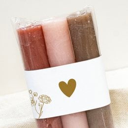 Heart-shaped candles in red, pink, and brown colors, packaged in a white box with a gold heart design.