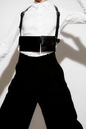 Black harness bag with adjustable straps and multiple pockets for storage.