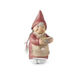 A decorative standing figurine of a smiling gnome or elf-like character wearing a red hat and holding a small flower.