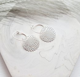 Silver hoop earrings with a hammered, textured disc design. Minimalist and modern style.