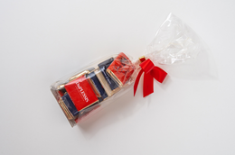 Dark chocolate 72% or milk chocolate 35% with French words, packaged in a clear plastic container with a red ribbon.