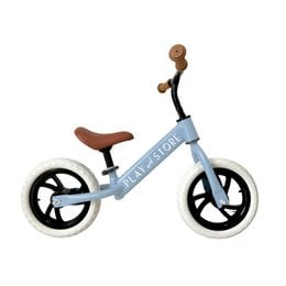 A green balance bike with a wooden handlebar and seat, designed for kids to learn balance and coordination.