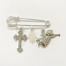 Silver-toned pin with charms including a cross, a hand, and a baby carriage, suitable as a gift for birth or baptism.