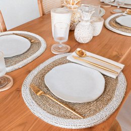  Seagrass placemat set with light blue color and cowrie shell accents. Circular shape with woven texture and natural fiber materials.
