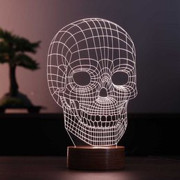 A 3D skull-shaped LED light made of wood, suitable for use as a table lamp.