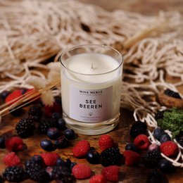  Scented candle with a sea berries fragrance, featuring a round, tall glass container.
