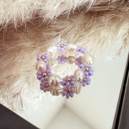 Delicate glass bead flower ring in lilac and pearl colors, featuring a unique and intricate design.