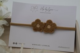  Brown hairband with crocheted flower details, suitable for kids.