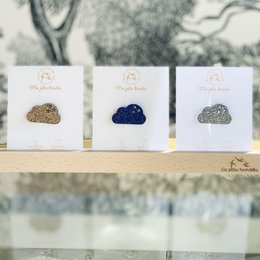 Glittering cloud-shaped brooch in gold, silver, and blue tones. Decorative accessory for clothing.