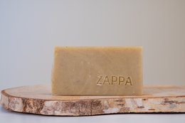 Natural Ghassoul clay soap bar with 'Zappa' branding on wooden display.