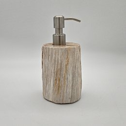  Petrified wood soap dispenser with a natural, rustic appearance and a stainless steel pump.