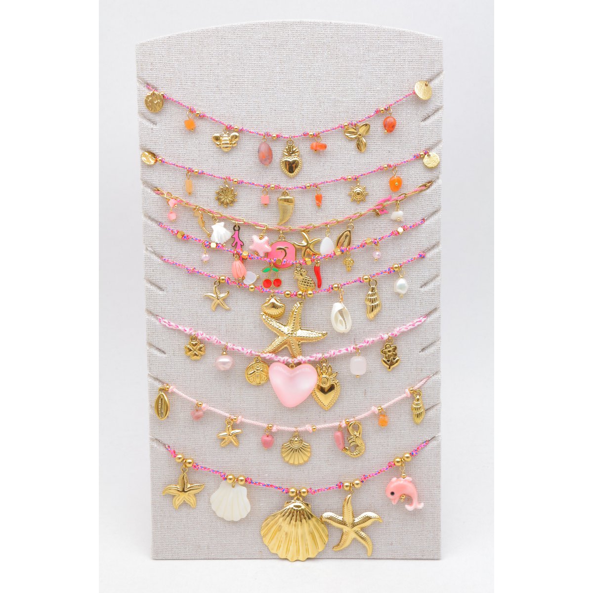 Lot de 8 colliers assortis en acier inoxydable, présentés sur un présentoir vertical en tissu.