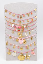 Lot de 8 colliers assortis en acier inoxydable, présentés sur un présentoir vertical en tissu.