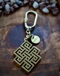 # Product Description
Brass geometric square keychain with Greek meander pattern, metal charm pendant, vintage style accessory.