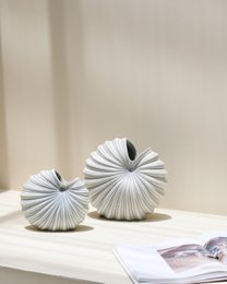Blue ceramic vase with pleated design, available in small and medium sizes.