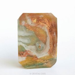 Gemstone soap with natural moss agate pattern in shades of green, orange, and white.