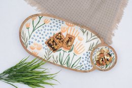 Divided wooden serving platter with floral pattern, featuring a round shape and two compartments for serving.