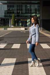 Gray knit cardigan, blue jeans, and white sneakers. Casual, comfortable outfit for everyday wear.