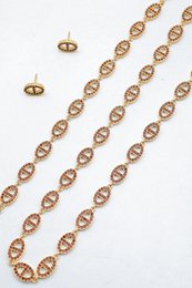 Ensemble assorti comprenant un collier, un bracelet en chaîne et une paire de boucles d'oreilles puces. Chaque bijou est composé d'une succession de maillons en forme de maille marine entièrement pavés de petits strass scintillants.