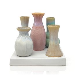 A set of 5 multicolored ceramic vases on a square tray. The vases feature a variety of shapes, sizes, and pastel color tones including white, pink, and green.