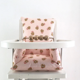 Soft, pink high chair cushion with brown floral pattern. Designed for comfort and style in baby's highchair.