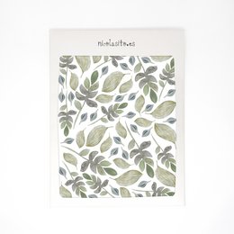 Vinilo Plantas is a kids room wallpaper featuring a repeating pattern of green and gray leaves in various shapes and sizes. The wallpaper has a natural, botanical aesthetic that would be suitable for decorating a child's bedroom or nursery.