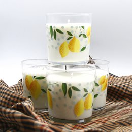 Panarea scented candle with pear design, round tall shape, white wax, and green leaf accents.