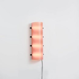A tall, cylindrical table lamp with a pink, translucent shade and a minimalist, modern design.